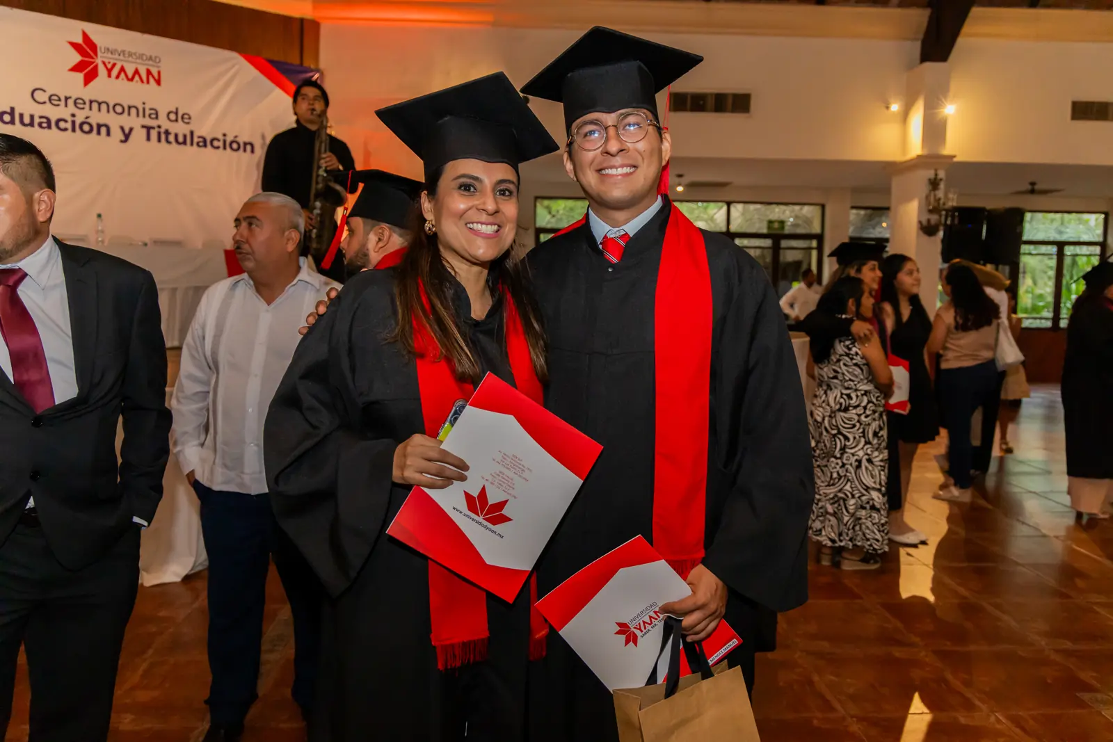 Egresados de Universidad YAAN con sus documentos al final de la ceremonia